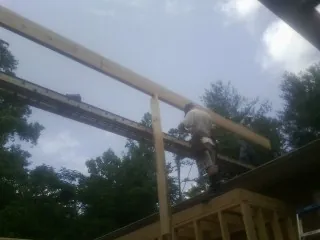 Carpenter setting a ridge beam over a new addition frame — Ice Dam Removal by Roofing Brothers in Sumerduck