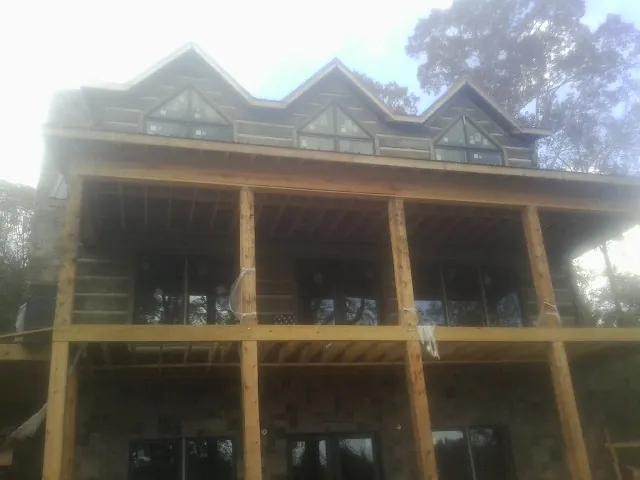Dormers and porch framing on a large log home under construction — Roof Coating work by our crew in Sumerduck
