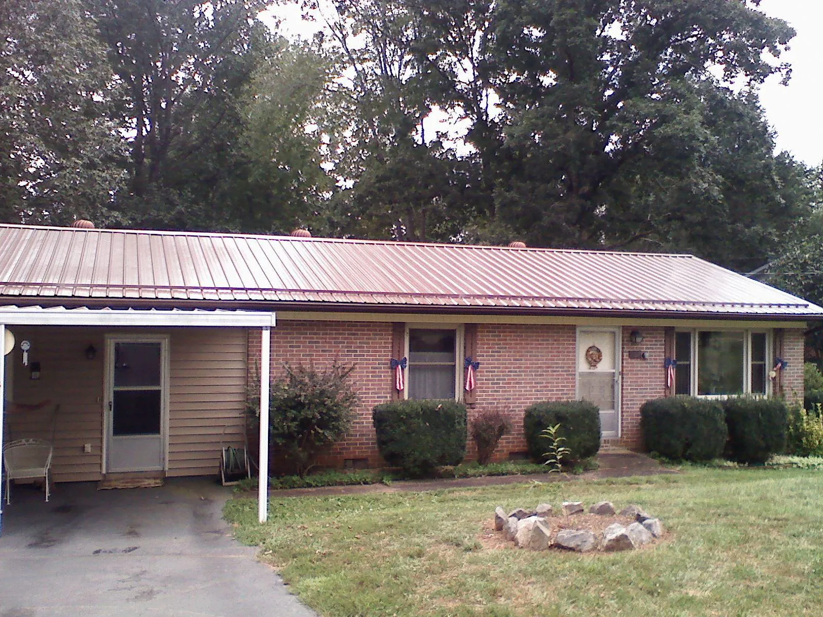 Bronze metal roof and carport on a brick ranch home — Roof Repair work by our crew in Sumerduck